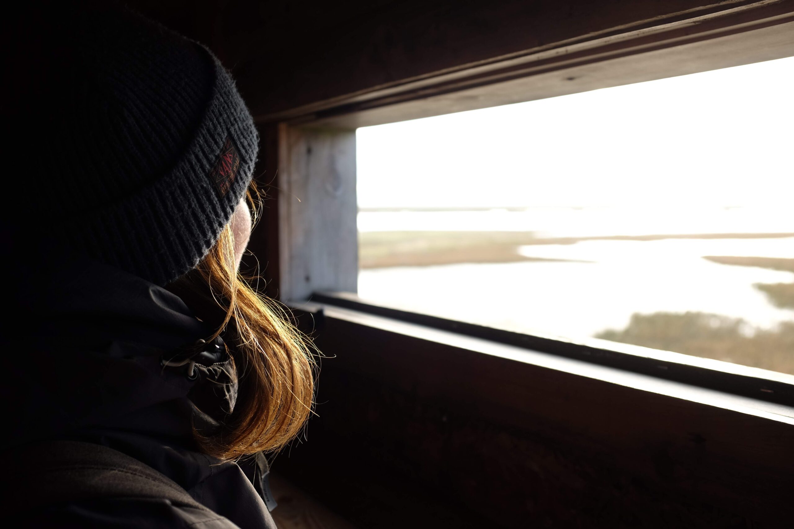 woman hat hair window looking out into nature