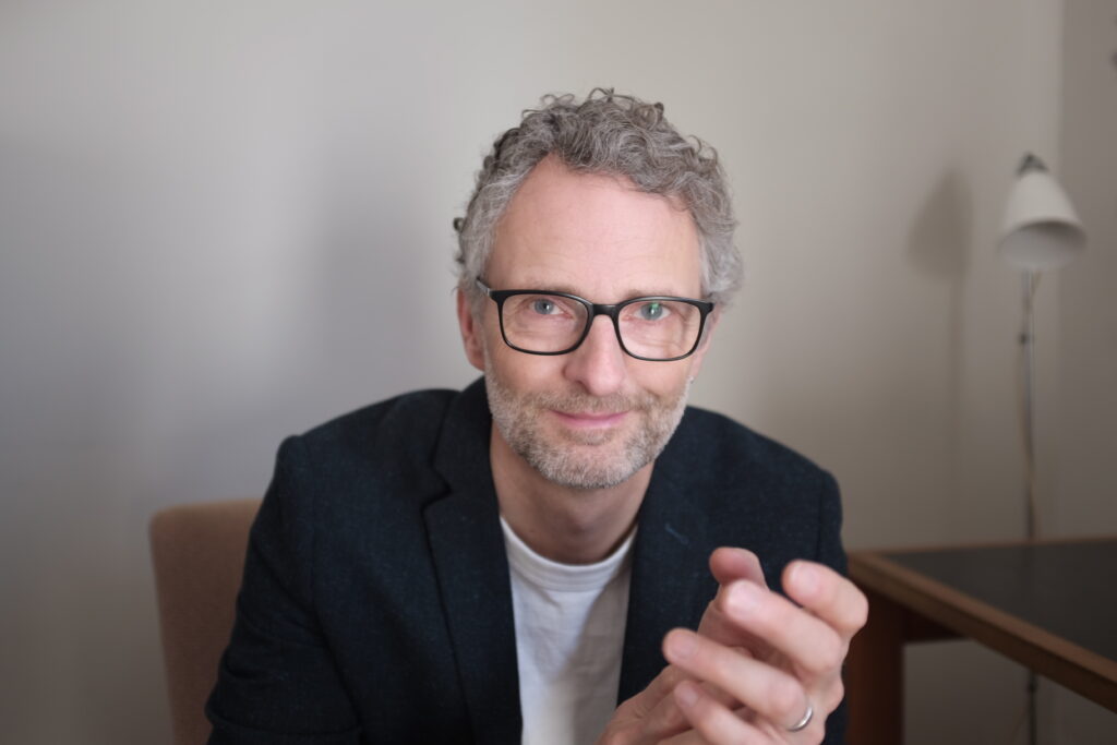 man smiling with glasses grey hair