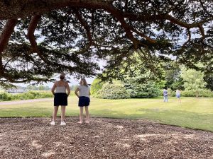 two women standing under tree