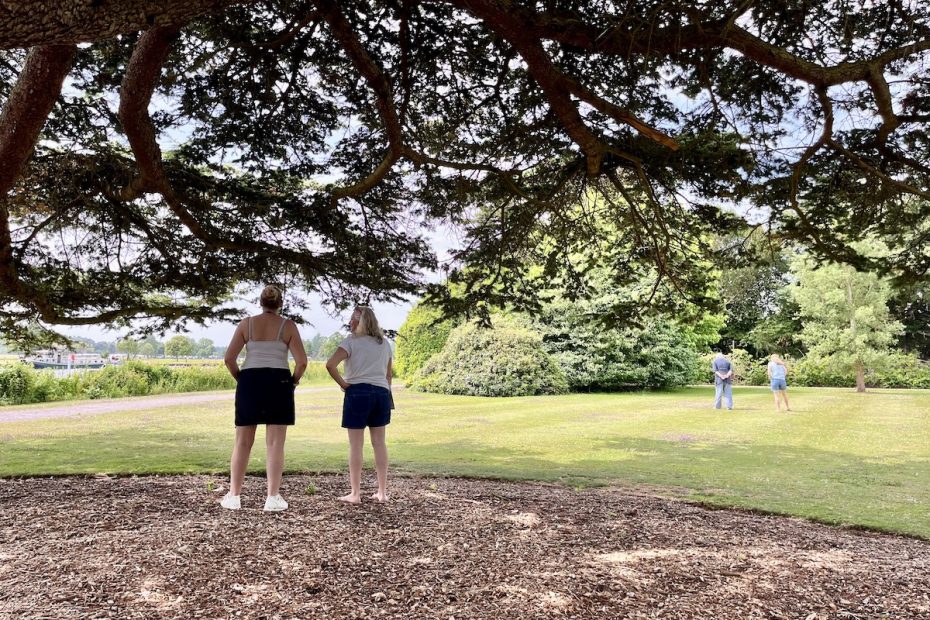 two women standing under tree
