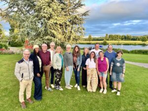 group of people standing outdoors looking at camera river in background